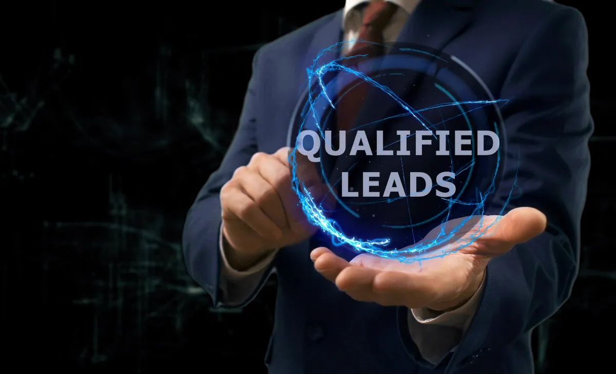 Man in a suit holding a blue hologram with the words Qualified Leads in the palm of his hand, representing lead management