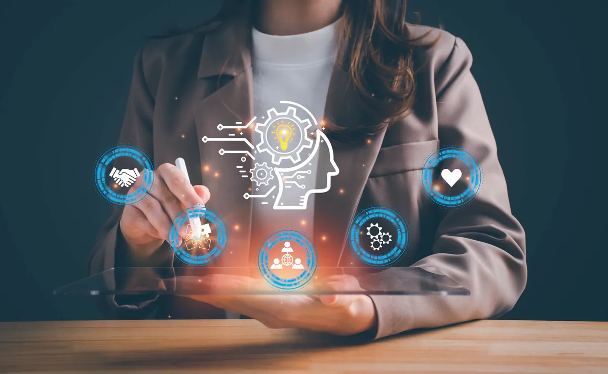 Woman in a blazer using a pen on a tablet with floating digital icons of networks, ideas and connections, symbolizing digital presence